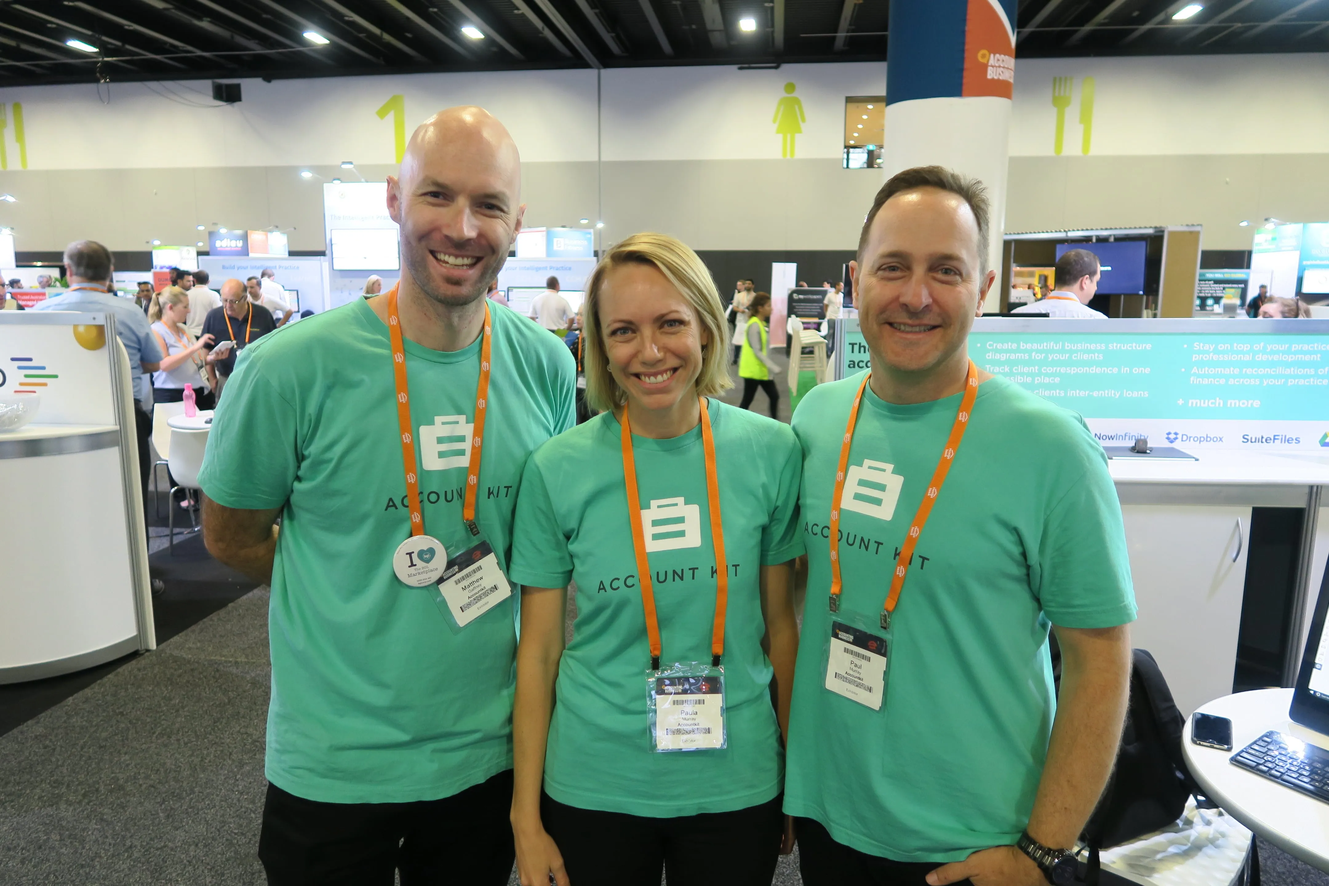 Three AccountKit team members in green AccountKit T-shirts at an accounting expo