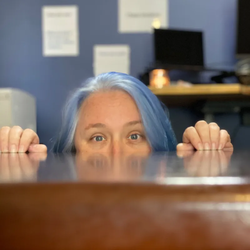 Kerrie Flood of Gilroy, Barnes & Associates peeking over the edge of her office desk